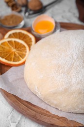 Photo of Fresh dough and ingredients on white table, closeup