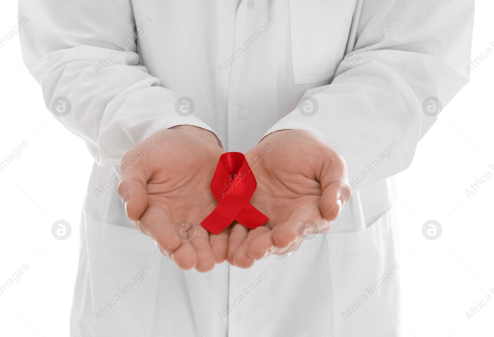 Photo of Doctor holding red awareness ribbon on white background, closeup. World AIDS disease day