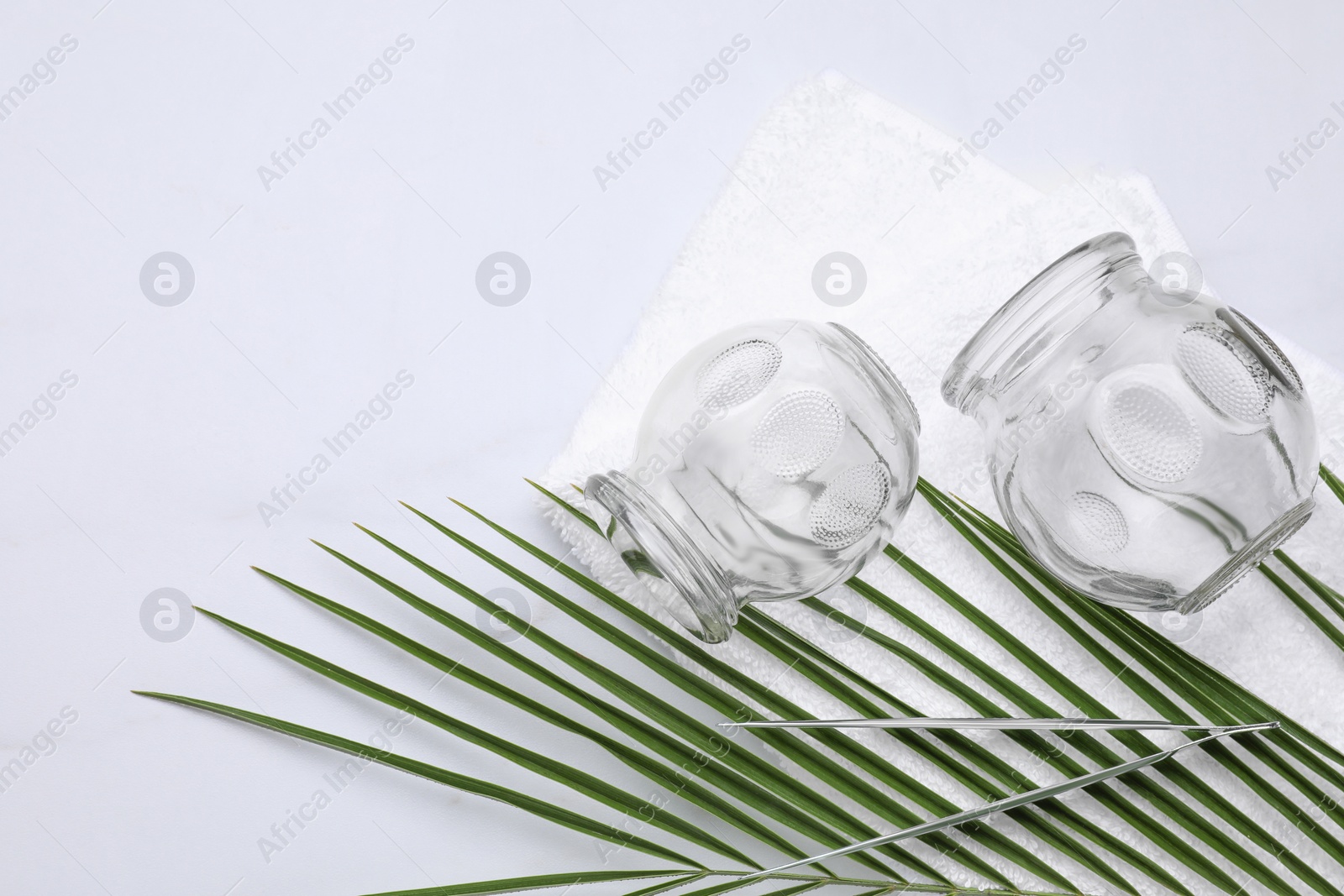 Photo of Cupping set and green leaf on white table, flat lay. Space for text