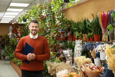 Photo of Male business owner with clipboard in his flower shop