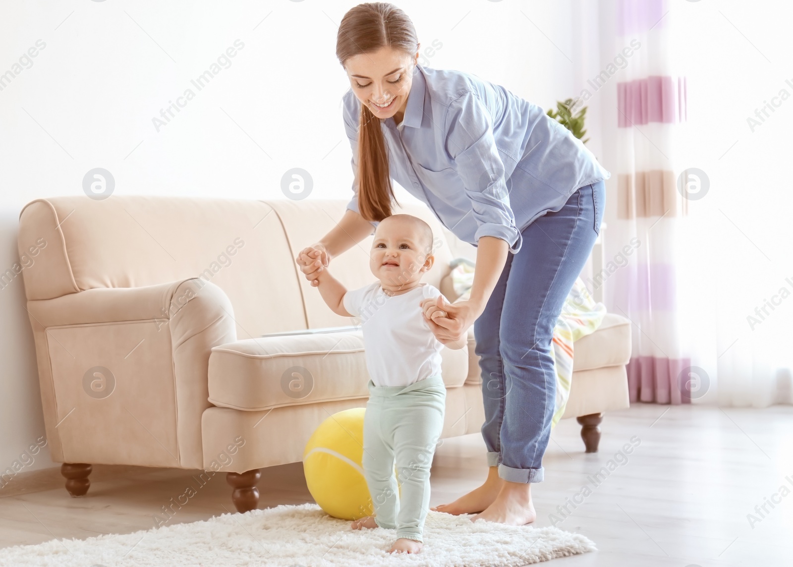 Photo of Baby taking first steps with mother's help at home