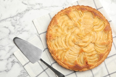 Photo of Delicious sweet pear tart with spatula on white marble table, flat lay