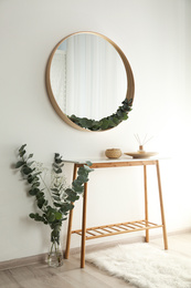 Photo of Round mirror with wooden frame in light room