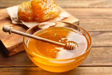 Photo of Fresh honey on wooden table, closeup view
