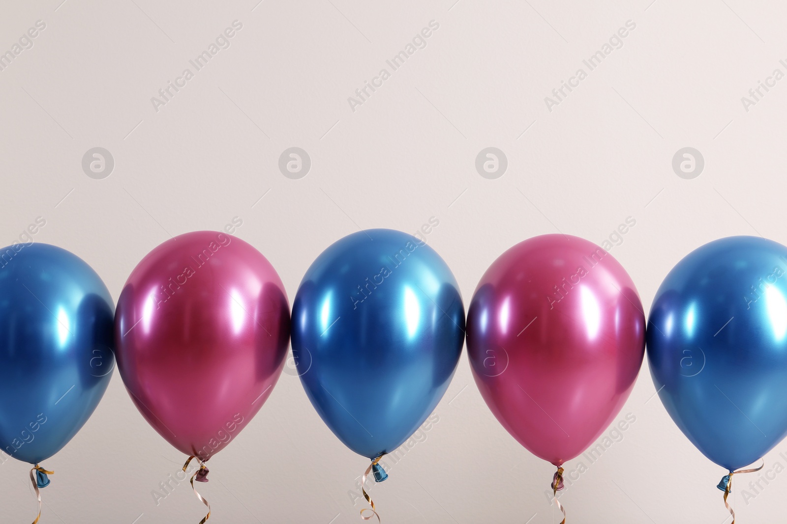 Photo of Color balloons with ribbons on white background. Space for text