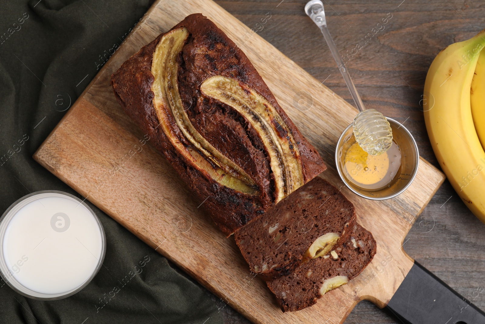 Photo of Delicious banana bread served on wooden table, flat lay
