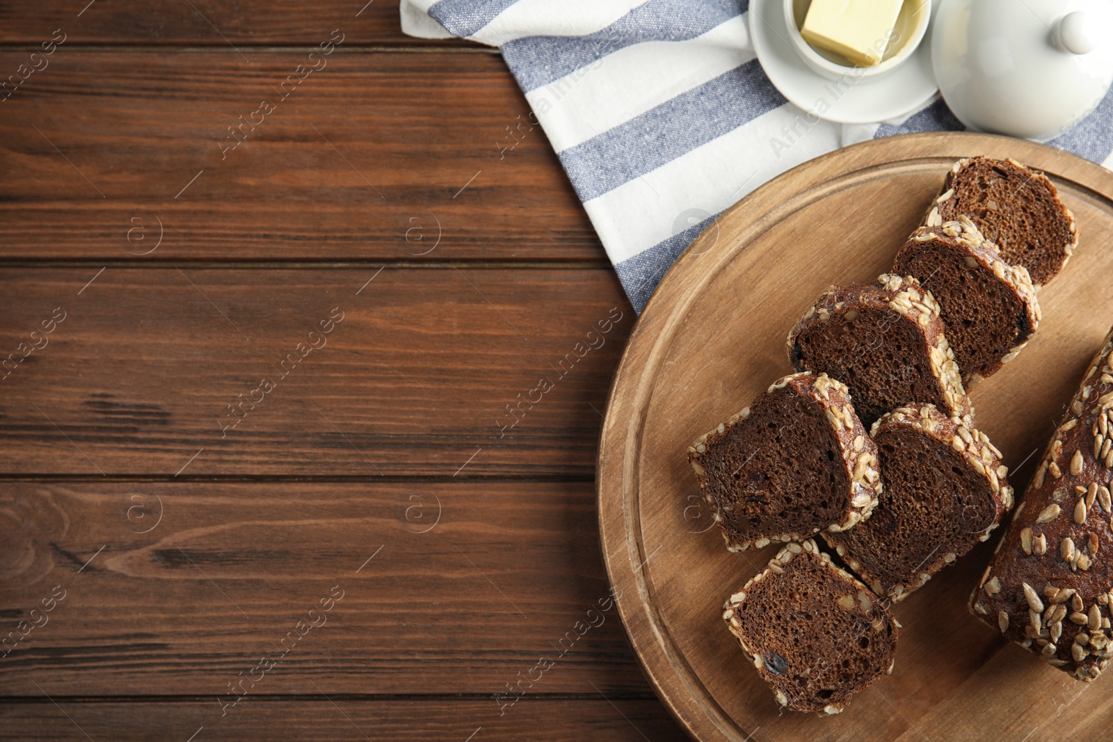 Photo of Tasty rye bread on wooden table, top view. Space for text