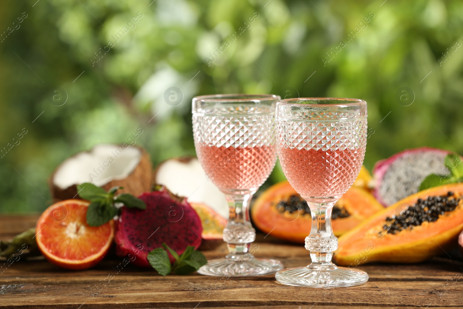 Photo of Delicious exotic fruits and wine on wooden table