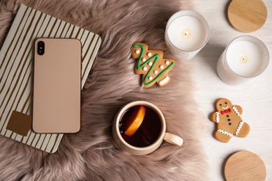 Flat lay composition with cup of hot mulled wine on furry blanket. Winter drink