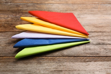 Photo of Colorful paper napkins on wooden background. Personal hygiene