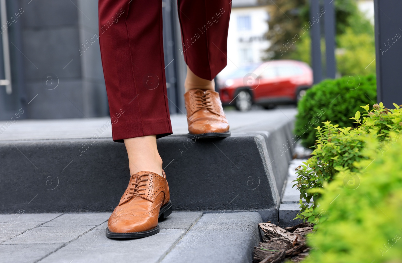 Photo of Woman in red pants and fashionable shoes walking on city street, closeup. Space for text