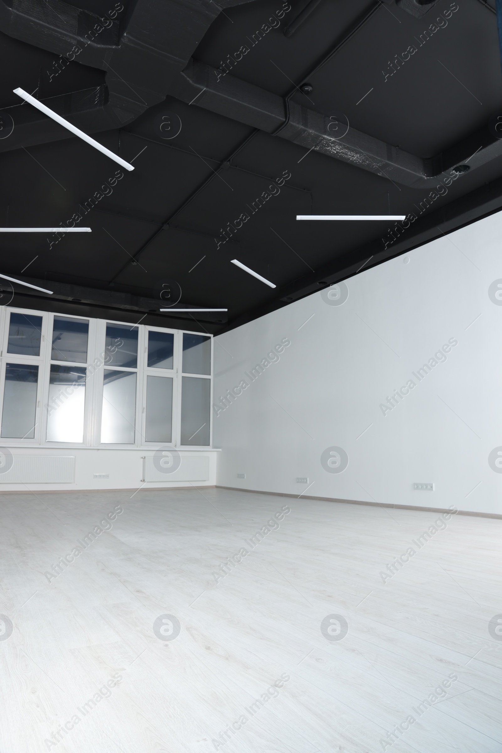 Photo of Empty office room with black ceiling and clean windows. Interior design