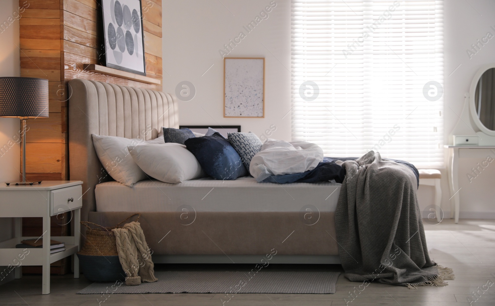 Photo of Comfortable bed with pillows and soft blanket in room. Stylish interior design