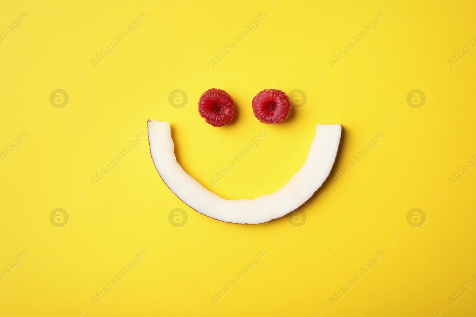 Photo of Funny flat lay composition with coconut and raspberry on color background