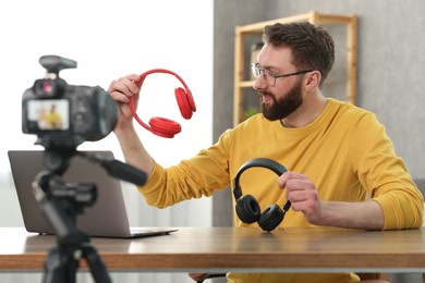 Technology blogger recording video review about headphones at home