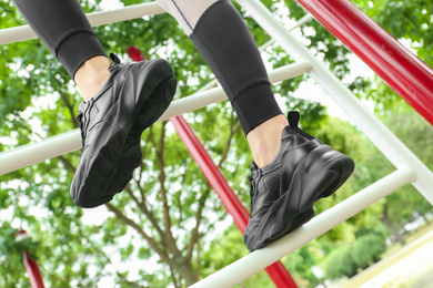 Photo of Woman in comfortable stylish shoes training outdoors, closeup