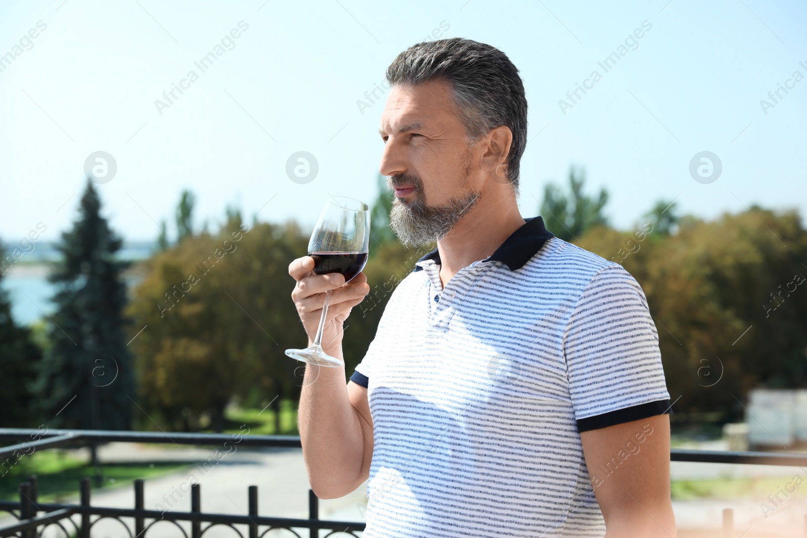 Photo of Man with glass of red wine outdoors