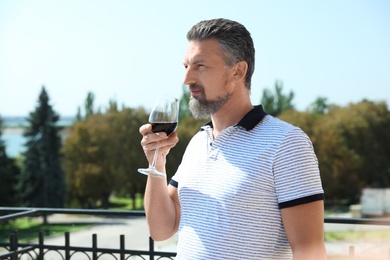 Photo of Man with glass of red wine outdoors