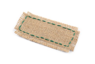 Photo of Piece of burlap fabric with green stitches isolated on white