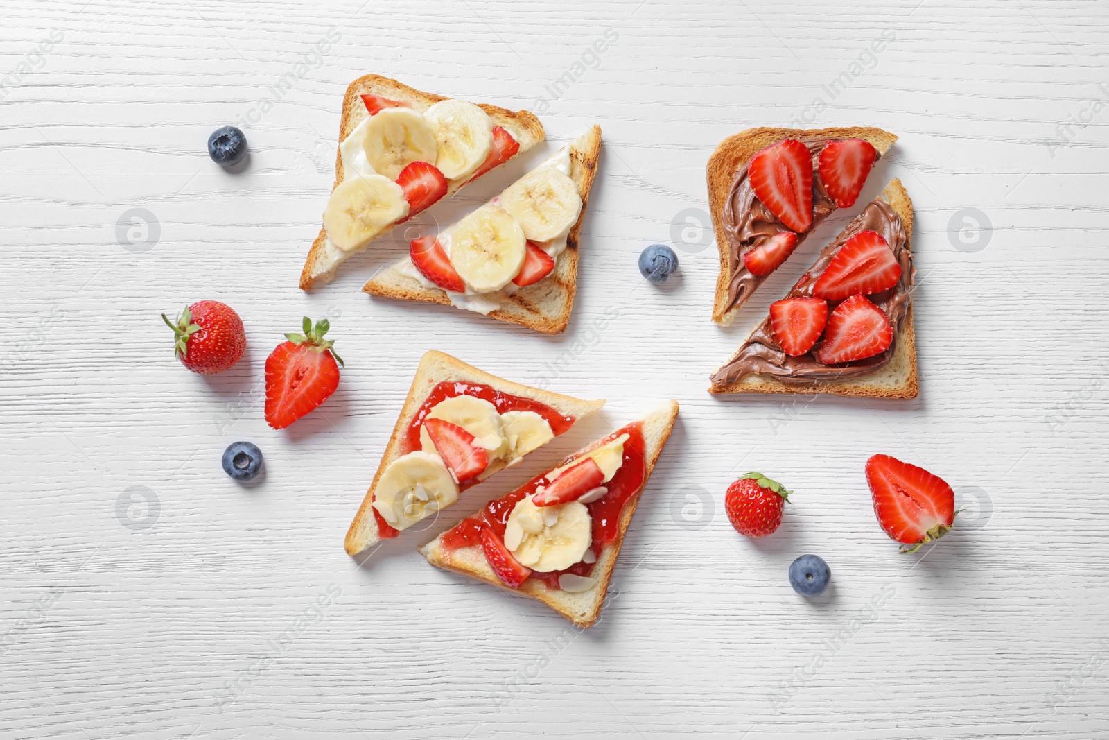 Photo of Tasty toast bread with banana and strawberry on light background