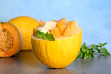 Photo of Fresh delicious sweet melons on table against color background