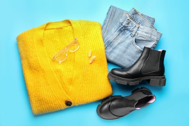 Flat lay composition with stylish boots on light blue background