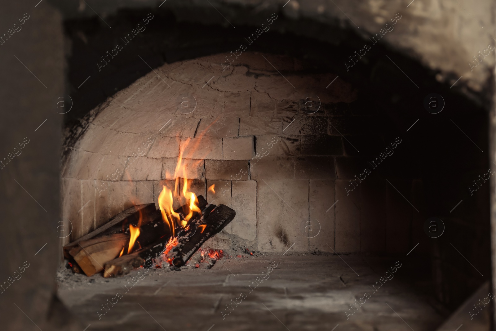 Photo of Oven with burning firewood in restaurant kitchen