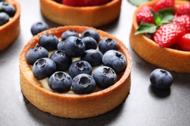 Tartlet with fresh blueberries on grey table, closeup. Delicious dessert