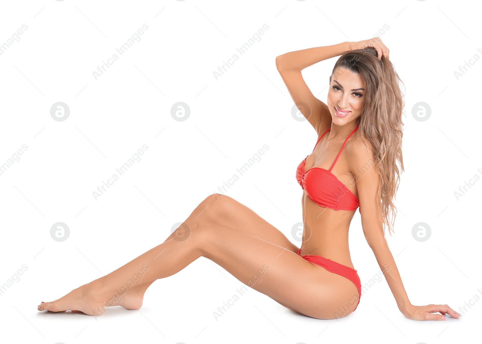 Photo of Pretty sexy woman with beautiful slim body in stylish bikini sitting on white background
