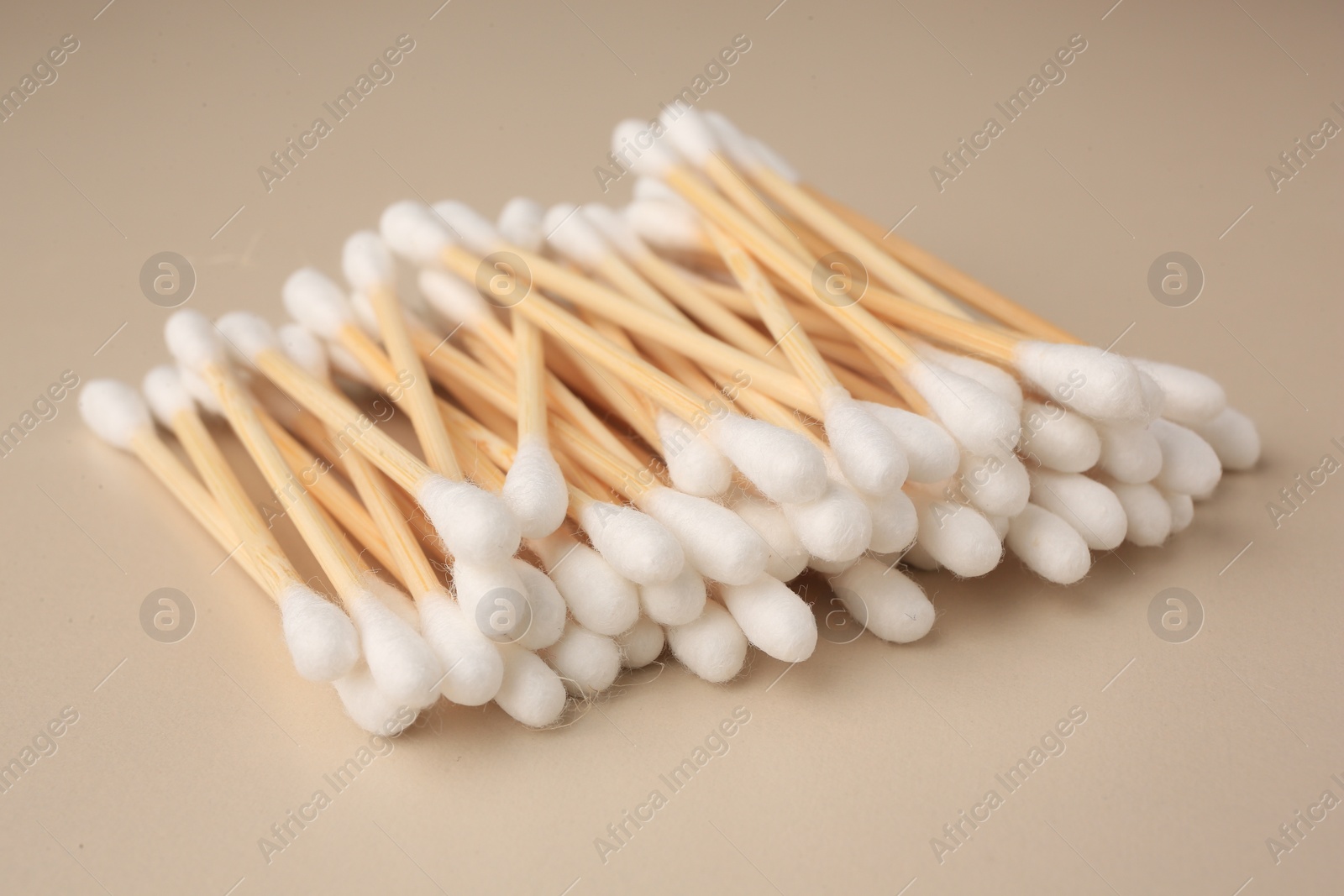 Photo of Many clean cotton buds on beige background, closeup