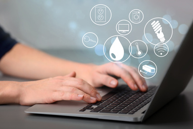 Image of Woman using laptop to control smart home, closeup. Automatic systems