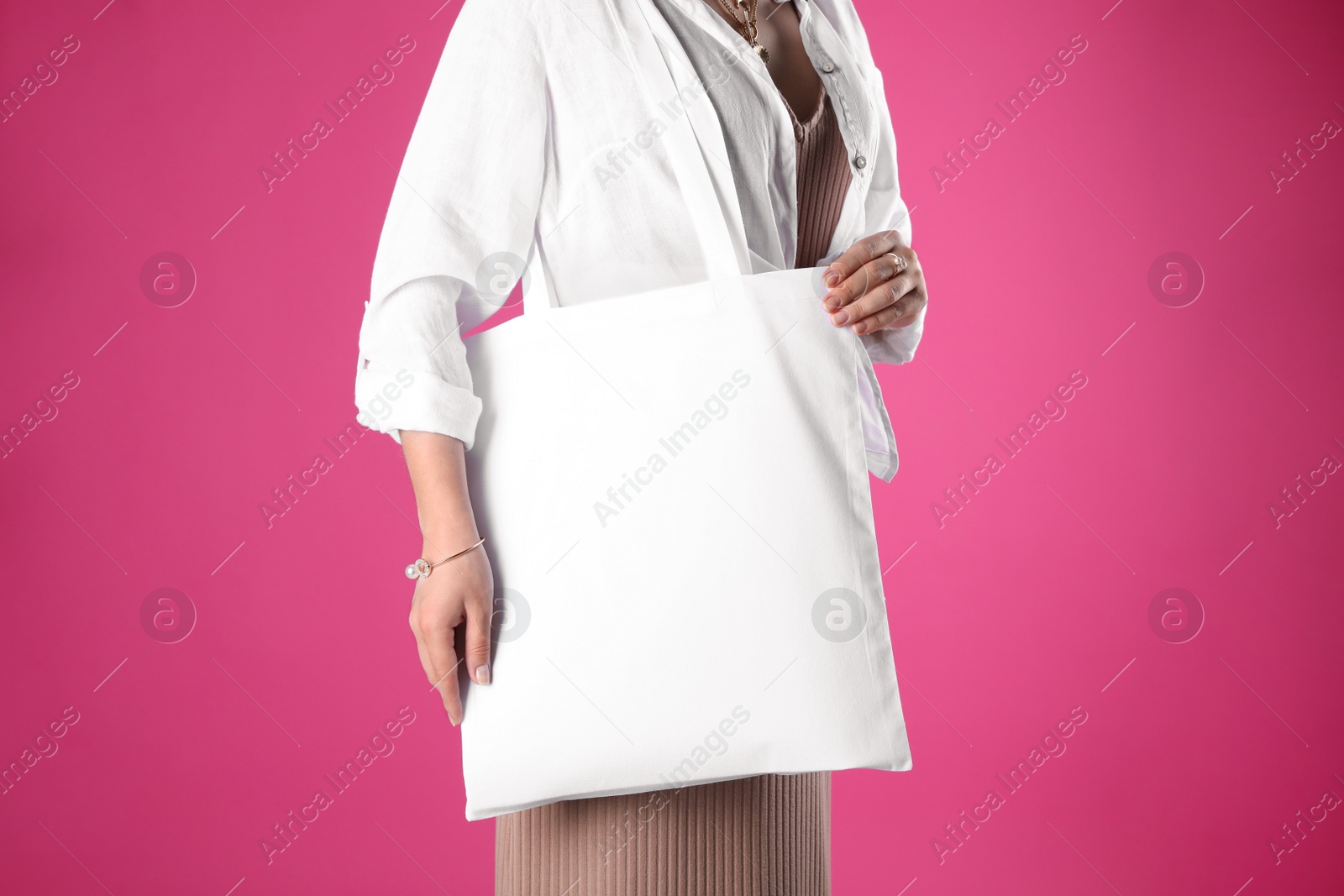 Photo of Woman with white textile bag on pink background, closeup. Space for design