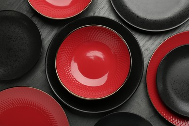 Photo of Beautiful ceramic plates and bowls on black table, top view