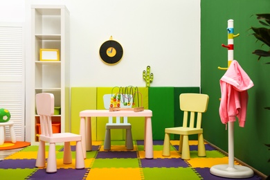 Stylish playroom interior with table and chairs