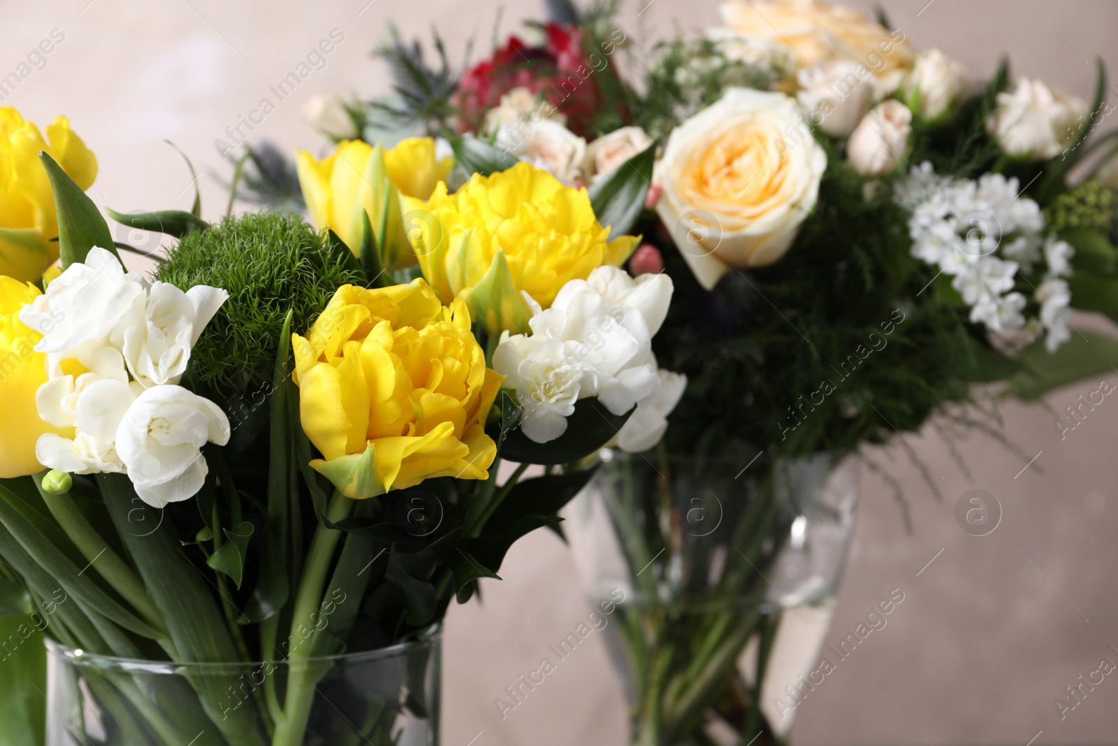 Photo of Beautiful bouquets with fresh flowers on grey background, closeup