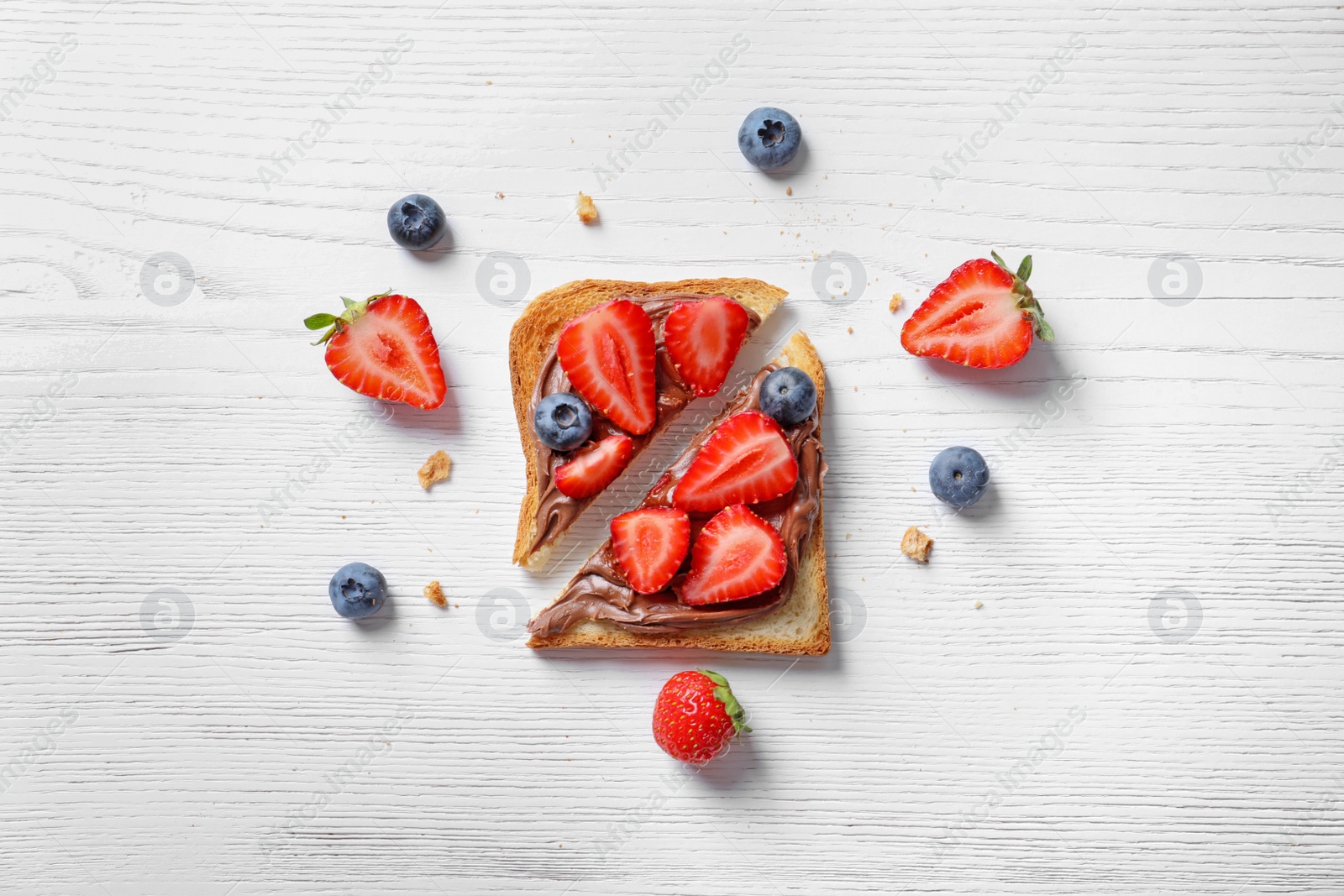 Photo of Flat lay composition with toast bread, strawberry and blueberry on light background