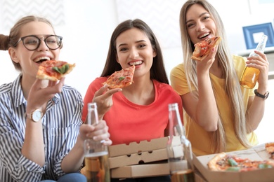 Young people having fun party with delicious pizza indoors