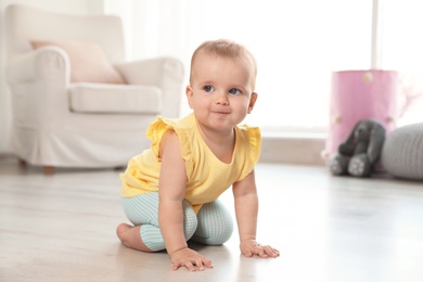 Cute baby girl on floor in room