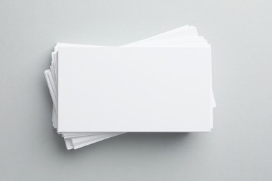 Blank business cards on light gray background, top view. Mockup for design