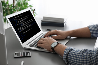 Image of Professional programmer working with laptop in office, closeup