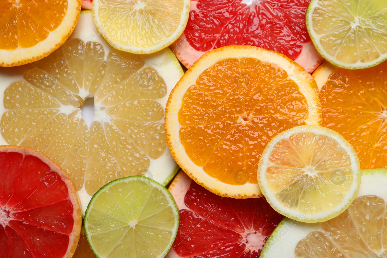 Photo of Slices of different citrus fruits as background, top view