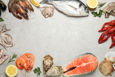 Photo of Fresh fish and seafood on light grey table, flat lay. Space for text
