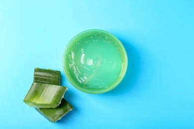 Photo of Aloe gel and plant on light blue background, flat lay