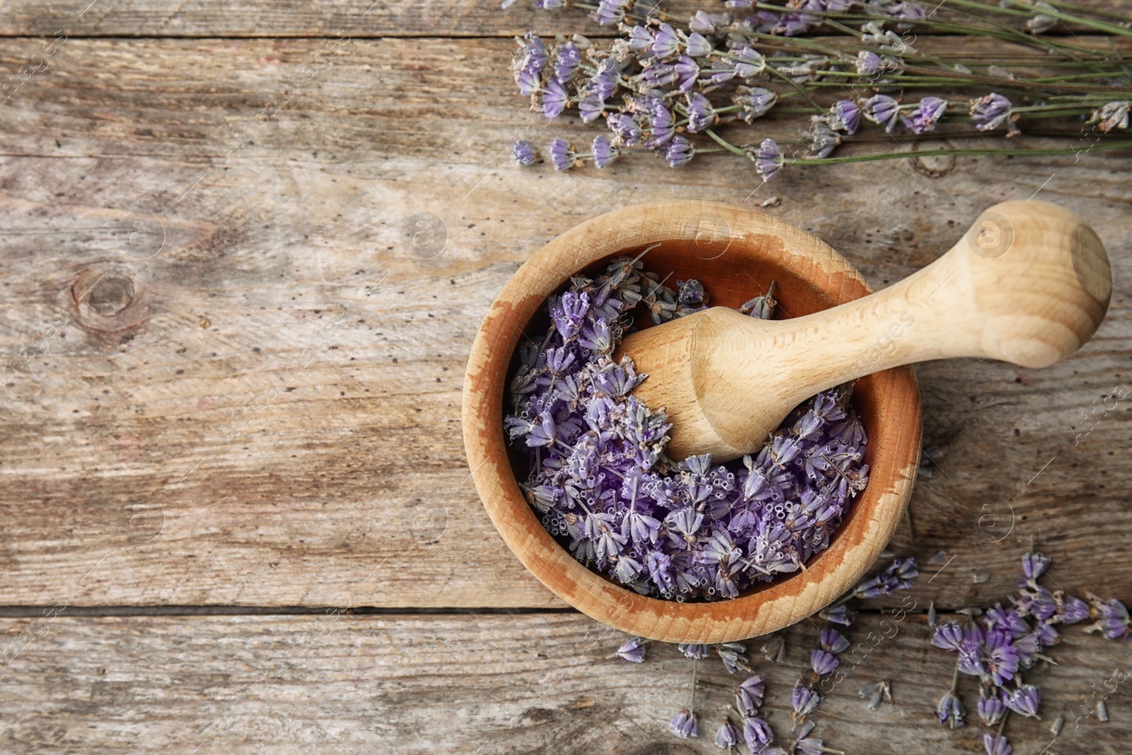 Photo of Mortar with lavender flowers on table, top view. Ingredient for natural cosmetic