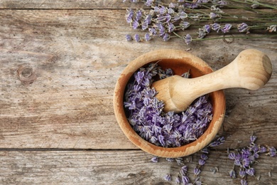 Mortar with lavender flowers on table, top view. Ingredient for natural cosmetic