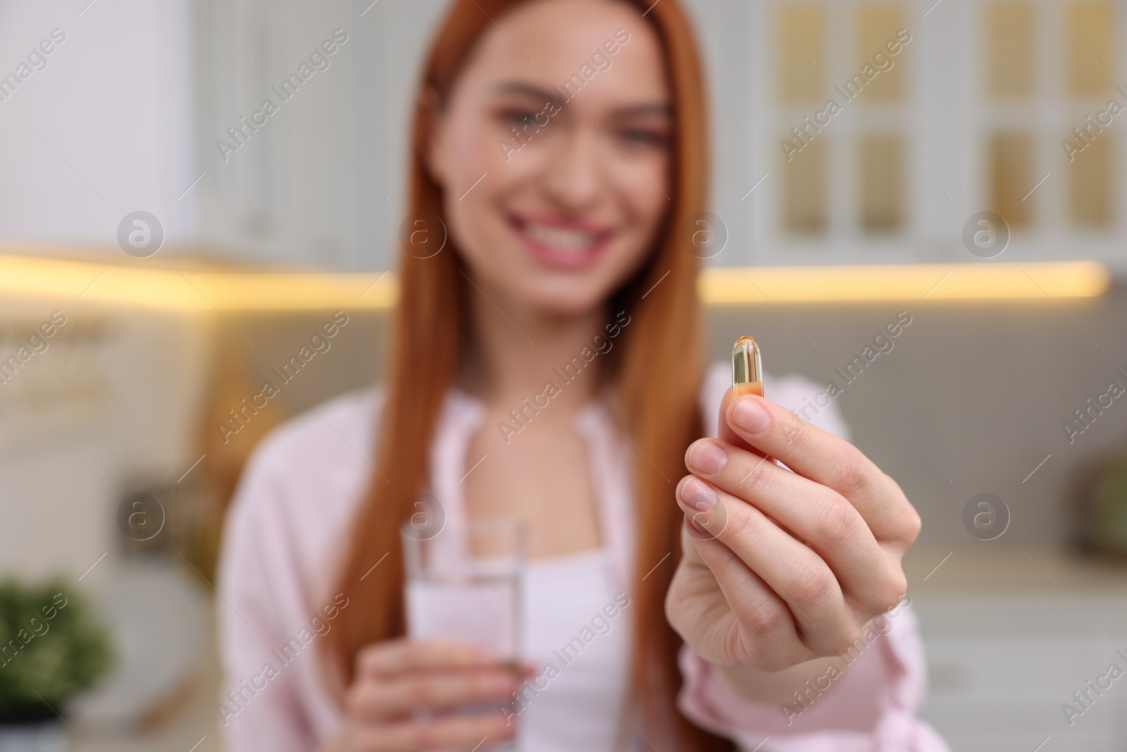 Photo of Beautiful young woman with vitamin pill and glass of water, selective focus
