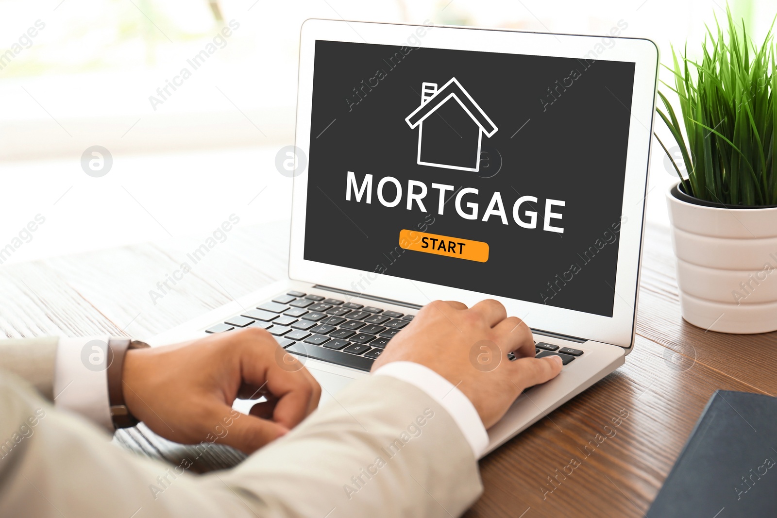Image of Mortgage concept. Man using modern laptop at table, closeup