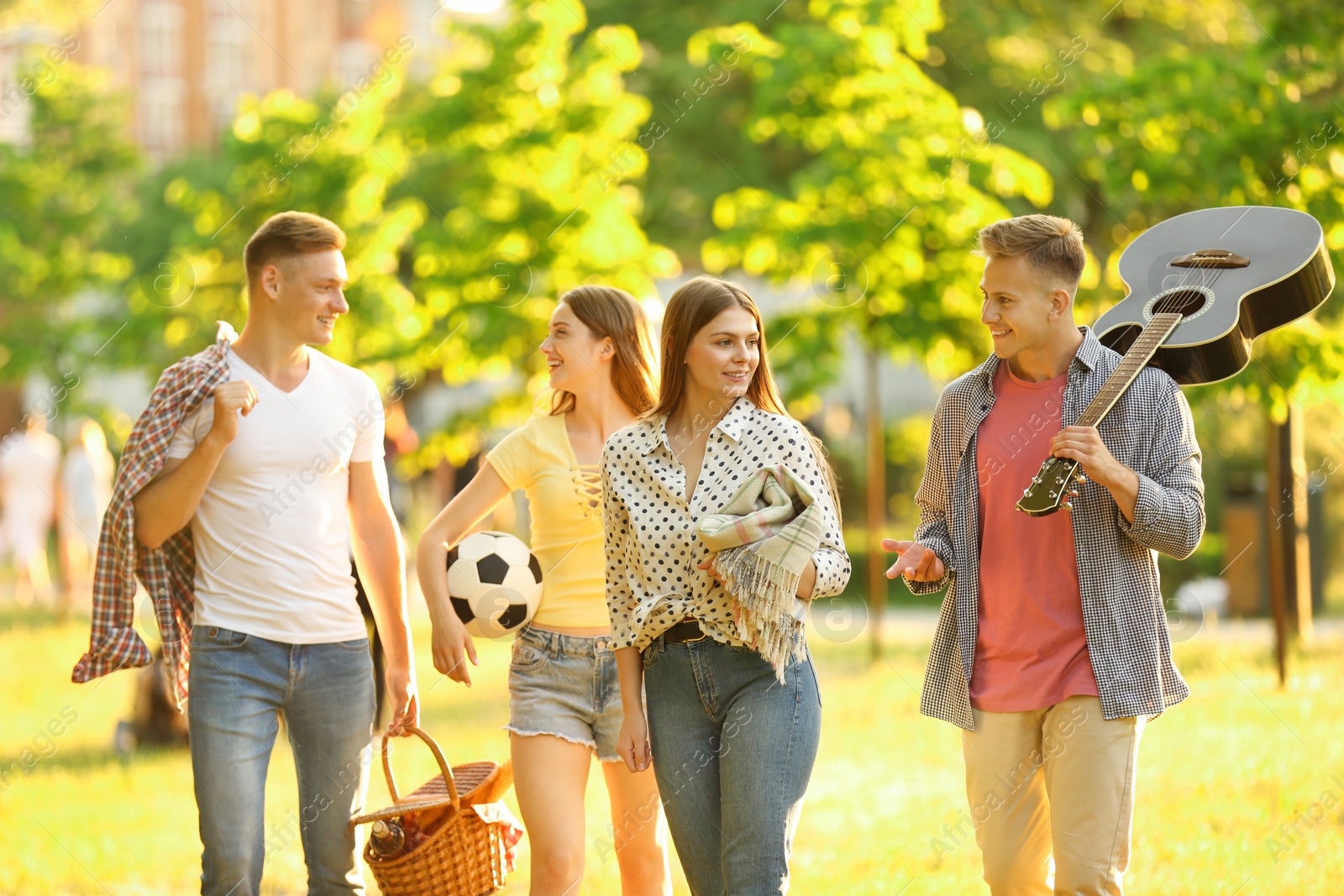 Photo of Young people with picnic basket in park on summer day