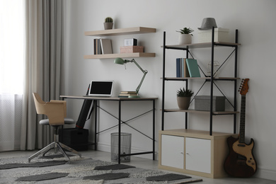 Photo of Modern teenager's room interior with workplace and shelving unit