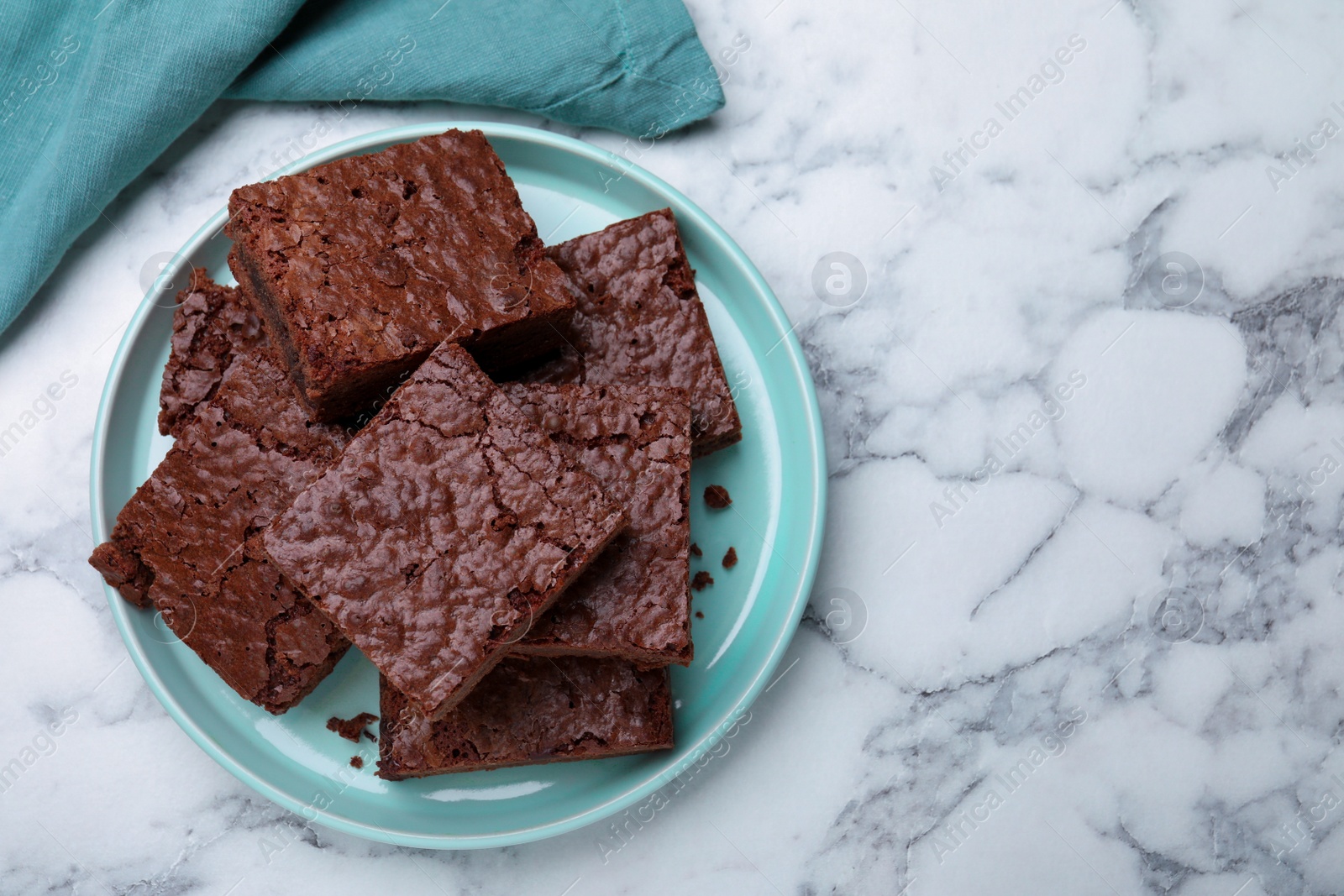 Photo of Delicious chocolate brownies on white marble table, flat lay. Space for text